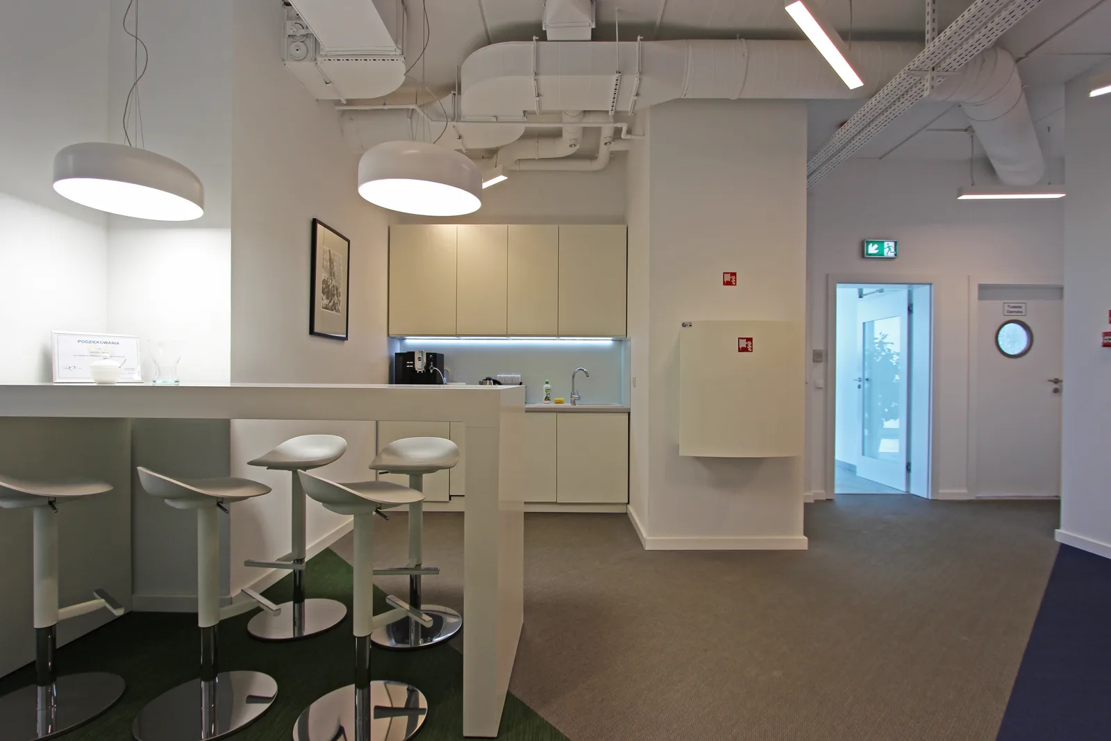 Workspace flooded with natural light showing the three-colour woven vinyl floor pattern and clean white desk surfaces