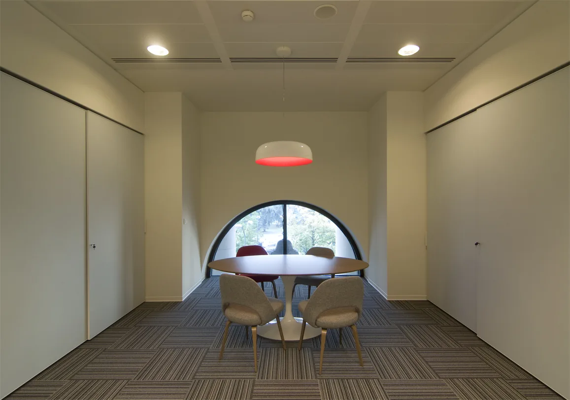 Level 2 breakout space with Bertoia Diamond chairs and Artemide Skydro pendants beneath brick arches