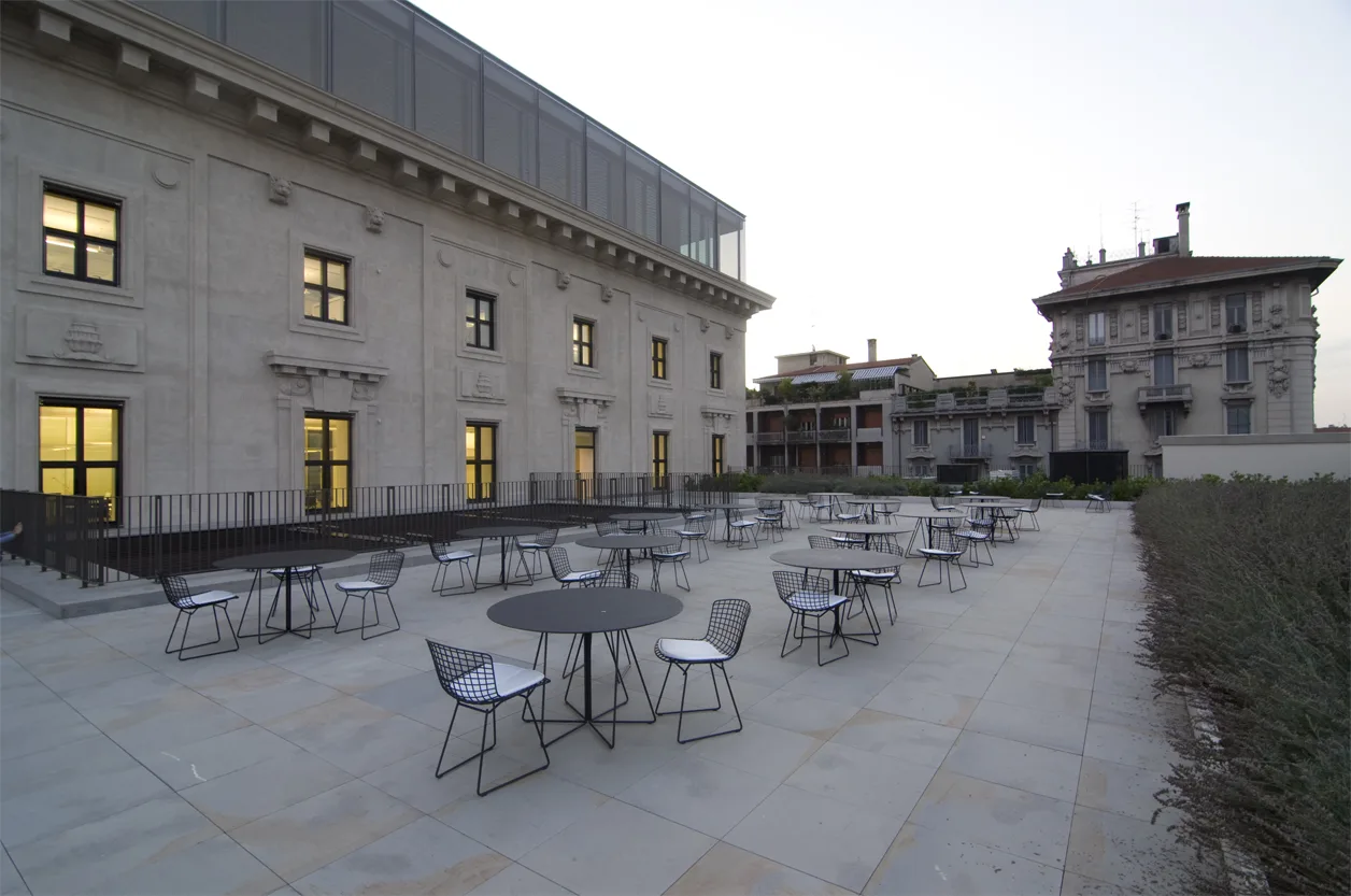 Terrace view showing the outdoor cafe area with parasols against the Palazzo Aporti facade