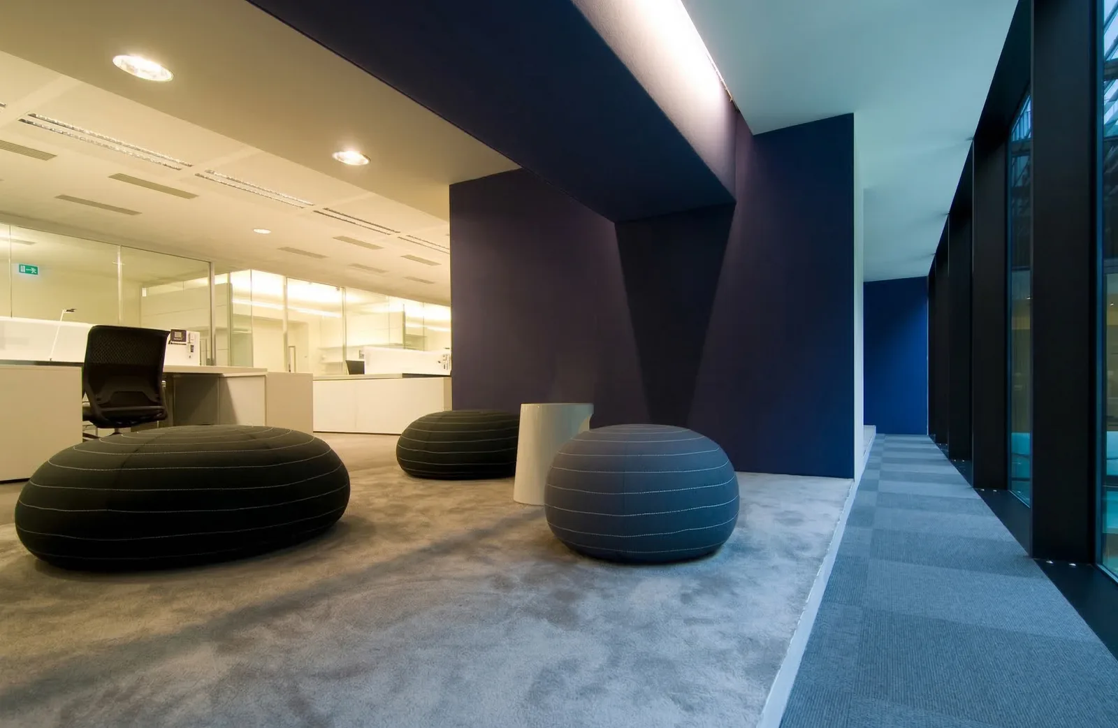 Ground floor reception with white Corian laser-cut panels featuring abstracted Disney motifs, bronze desk, and Perle stone flooring