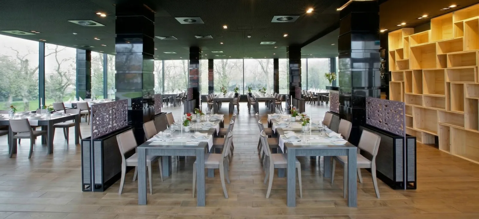 Restaurant Werbena interior with panoramic glazing, set tables, botanical dividers, and wood shelving