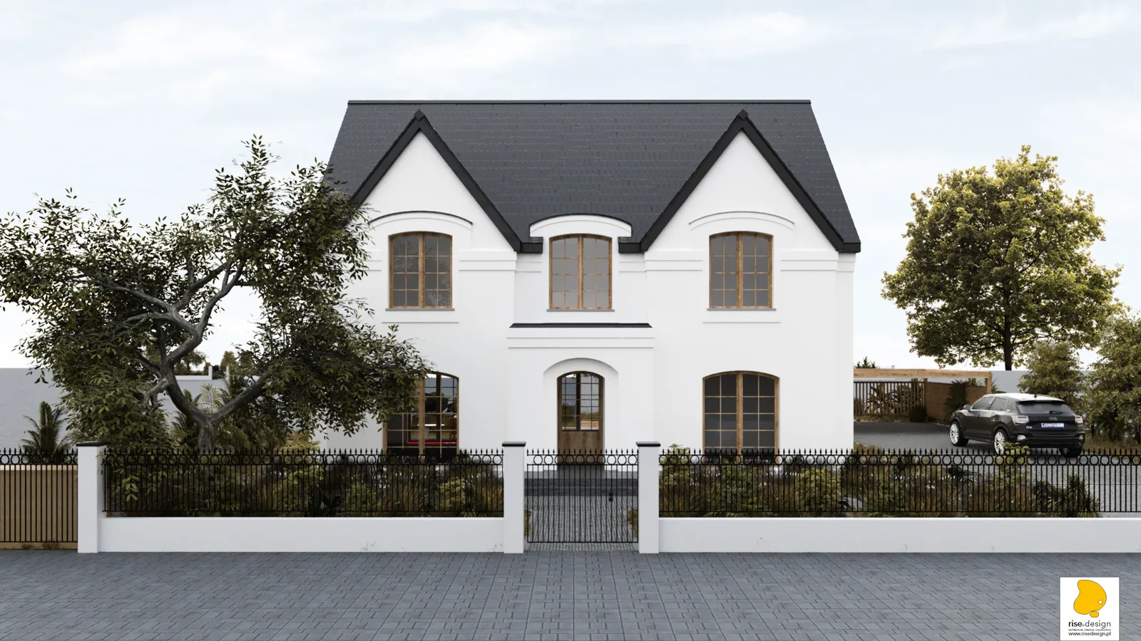 Detail: driveway approach to covered carport showing cobblestone paving, carport structure with open-work side walls, and white masonry fence with wrought-iron gate in background