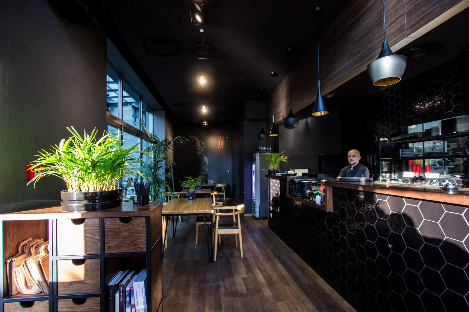Interior: ground floor sushi bar entrance with oak storage unit, plants, hexagonal tiles, and chef at sushi counter