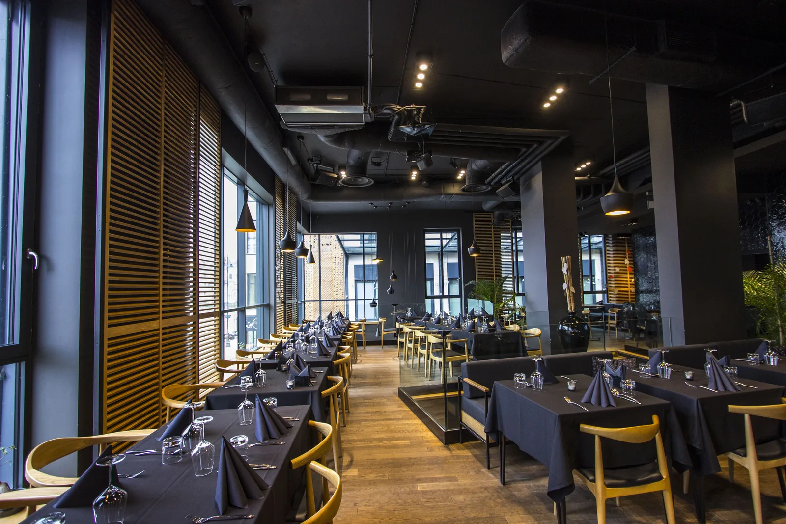 Interior: upper floor dining full space toward hexagonal tile wall, exposed HVAC, pendant lights, and set tables