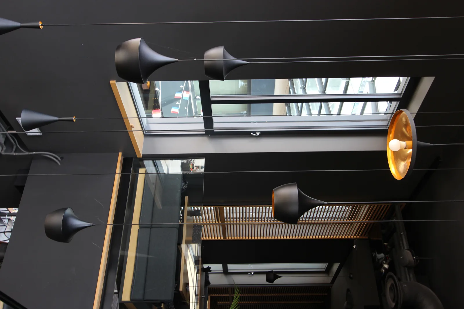 Interior: Tom Dixon Beat pendant cluster looking up through double-height void, glass balustrade, and venetian blinds above
