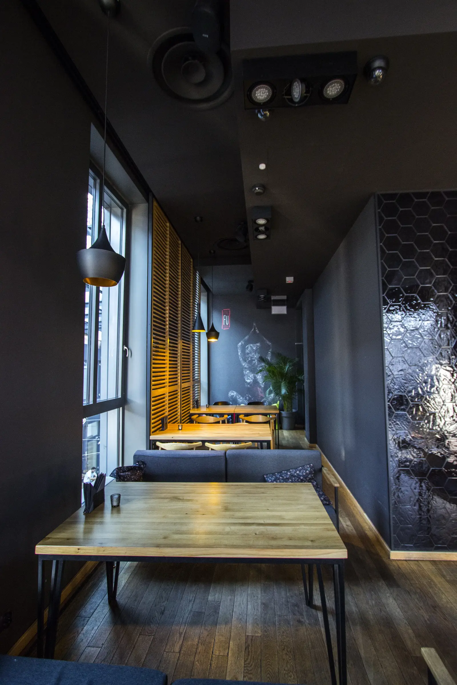 Interior: upper floor booth seating with hexagonal tile wall, oak tables, banquette, and Tom Dixon pendant above