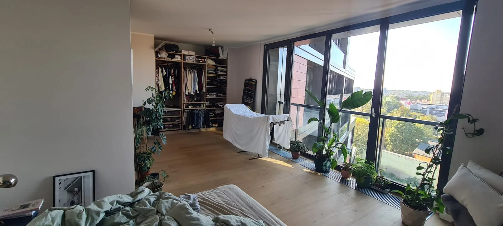 Documentary: pre-renovation entrance photograph with client Nathalie and dog at the apartment front door showing the existing hallway condition of the 94 square metre high-rise apartment before redesign