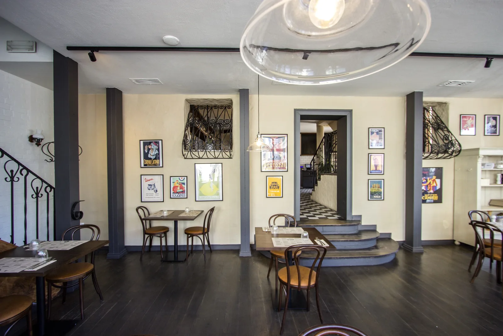 First floor detail showing communal table setting with rattan pendants at varying heights and reclaimed timber floor beneath