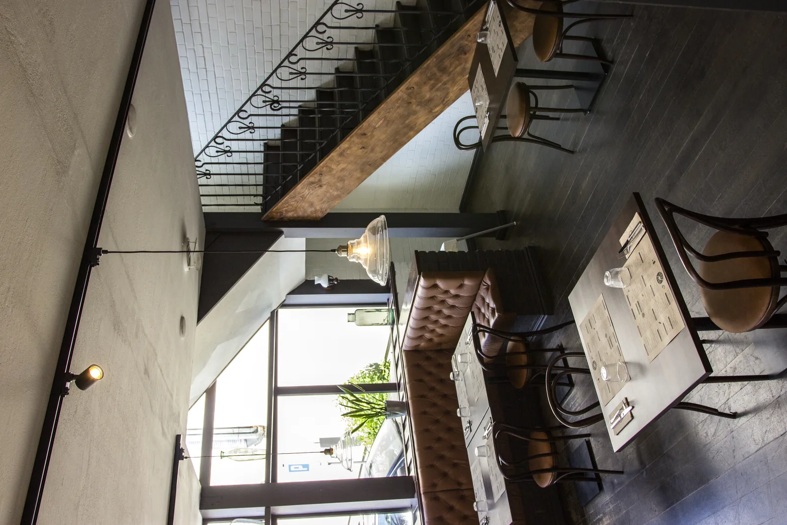 Ground floor corridor with wrought iron window grate used as decorative wall element, warm plaster walls, and pendant lighting