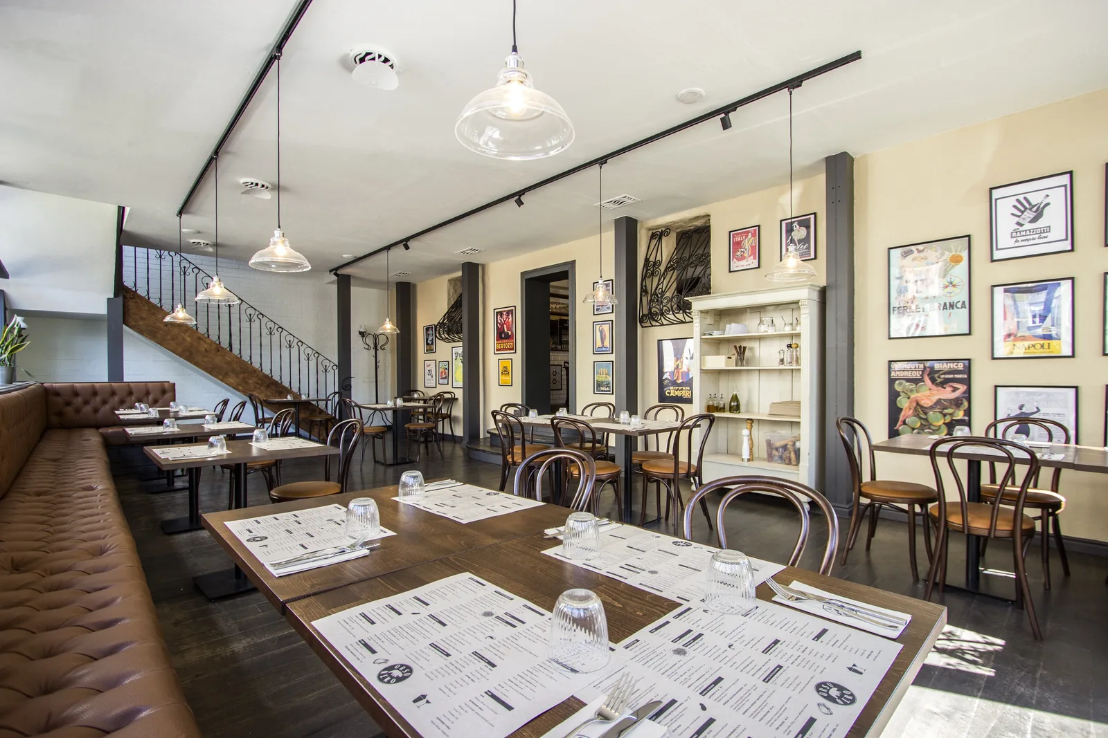 Ground floor wide view showing the full depth of the trattoria from bar through dining to garden windows beyond
