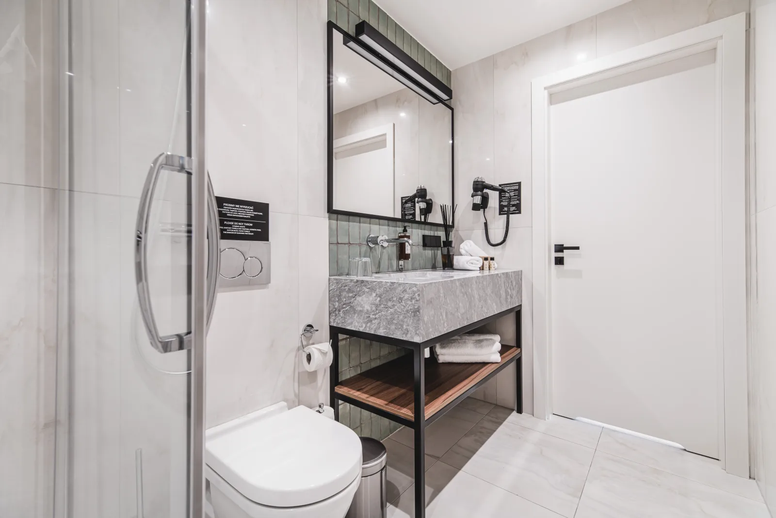 Vanity with round mirror, green zellige tile accent wall