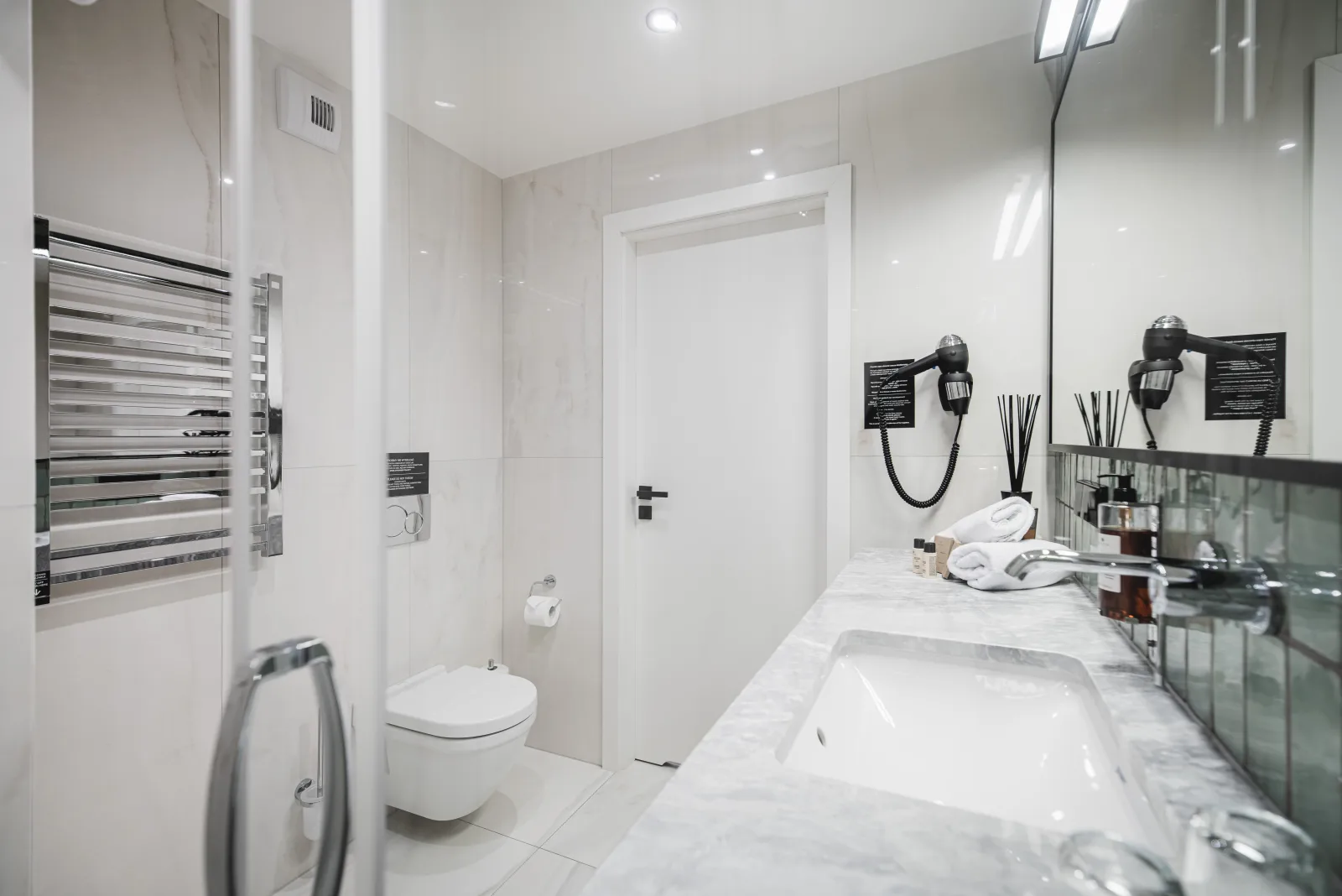 Wide bathroom view, vanity and shower, green zellige tile wall