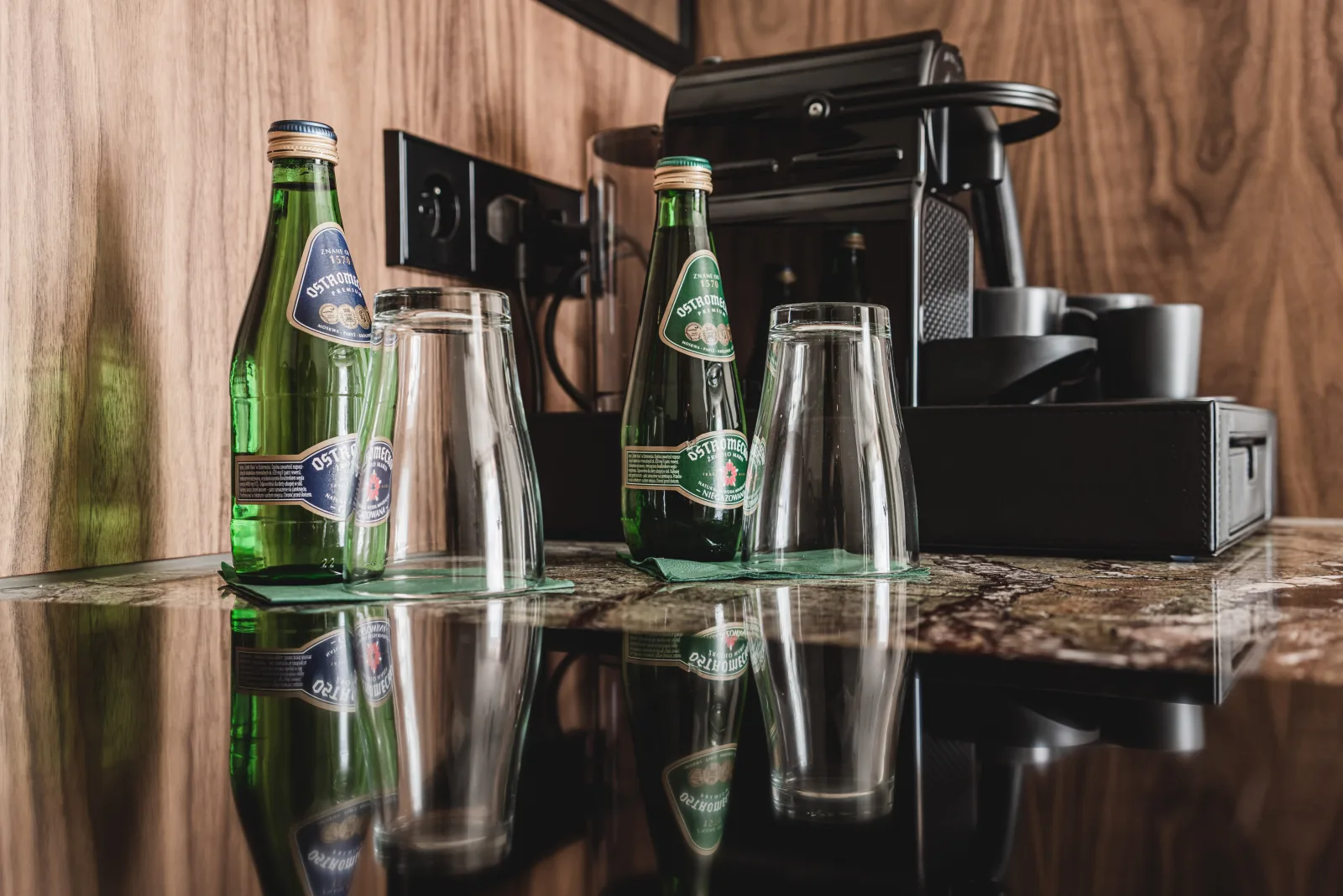 Water bottles and glasses arranged on marble counter surface