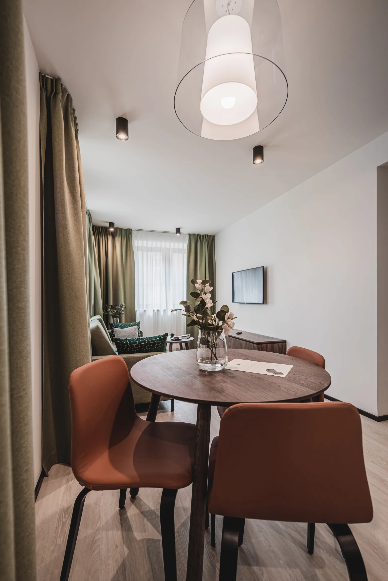 Dining table with orange leather chairs, pendant lamp