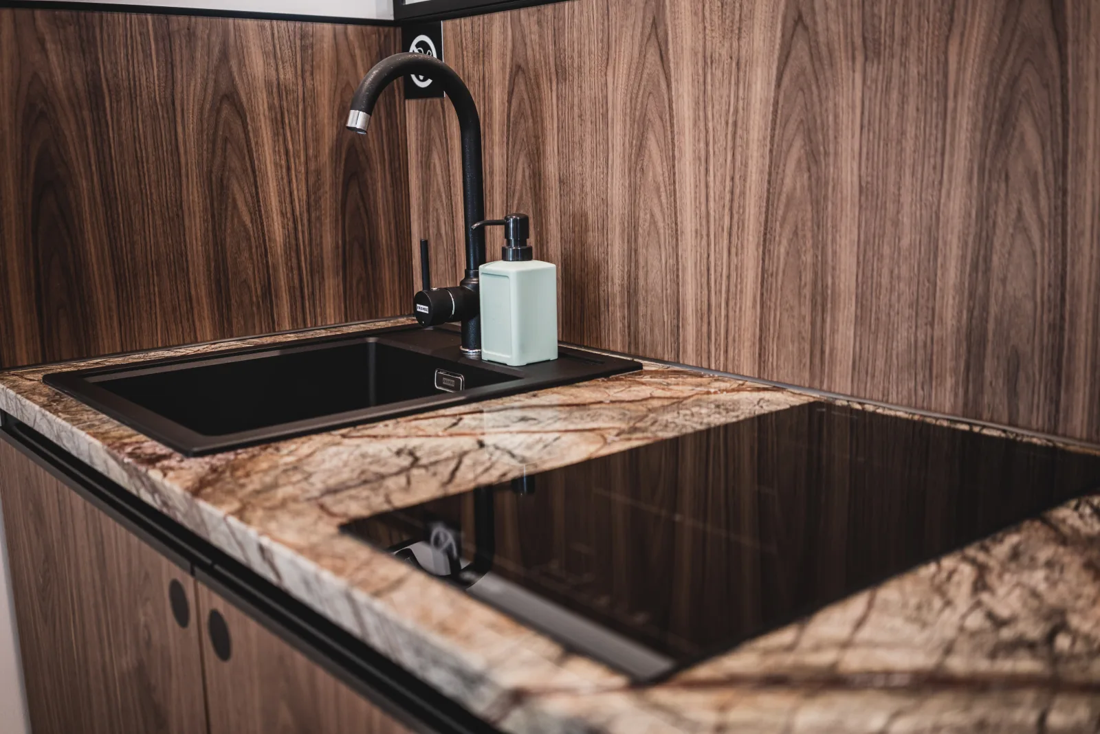Kitchen sink detail on rainforest marble countertop