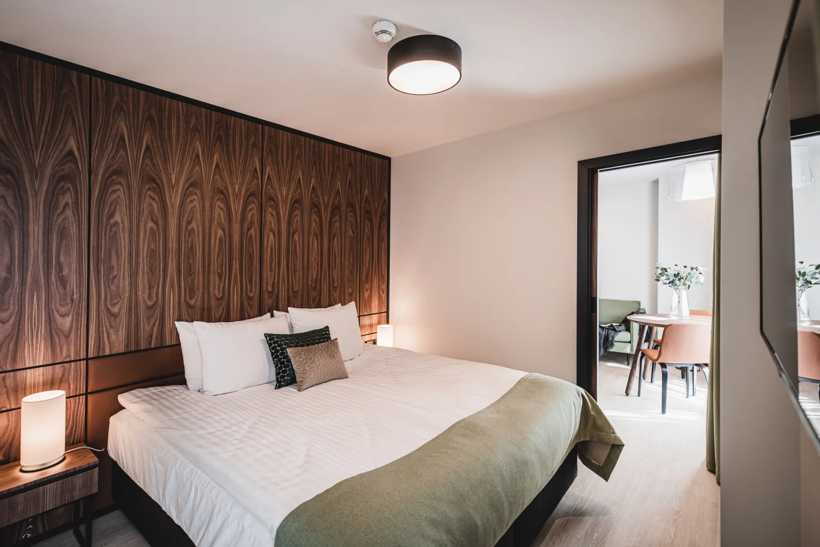 Bedroom with walnut panels, desk area, warm ambient lighting