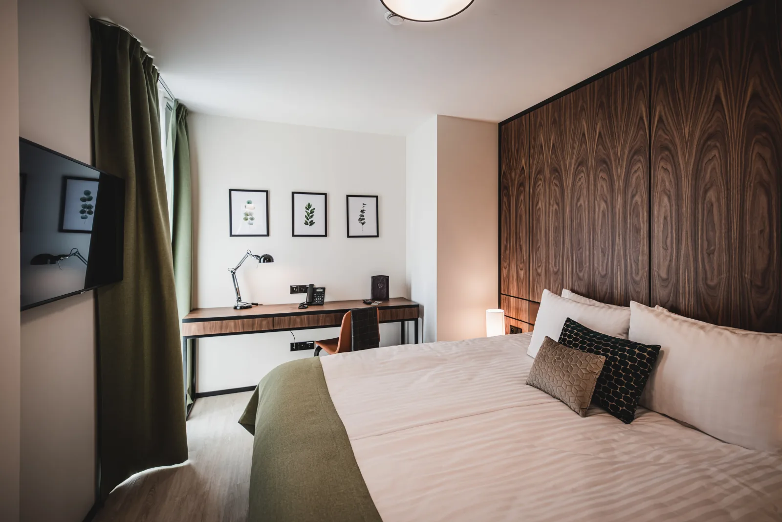Bedroom with white bed, walnut headboard, pendant light