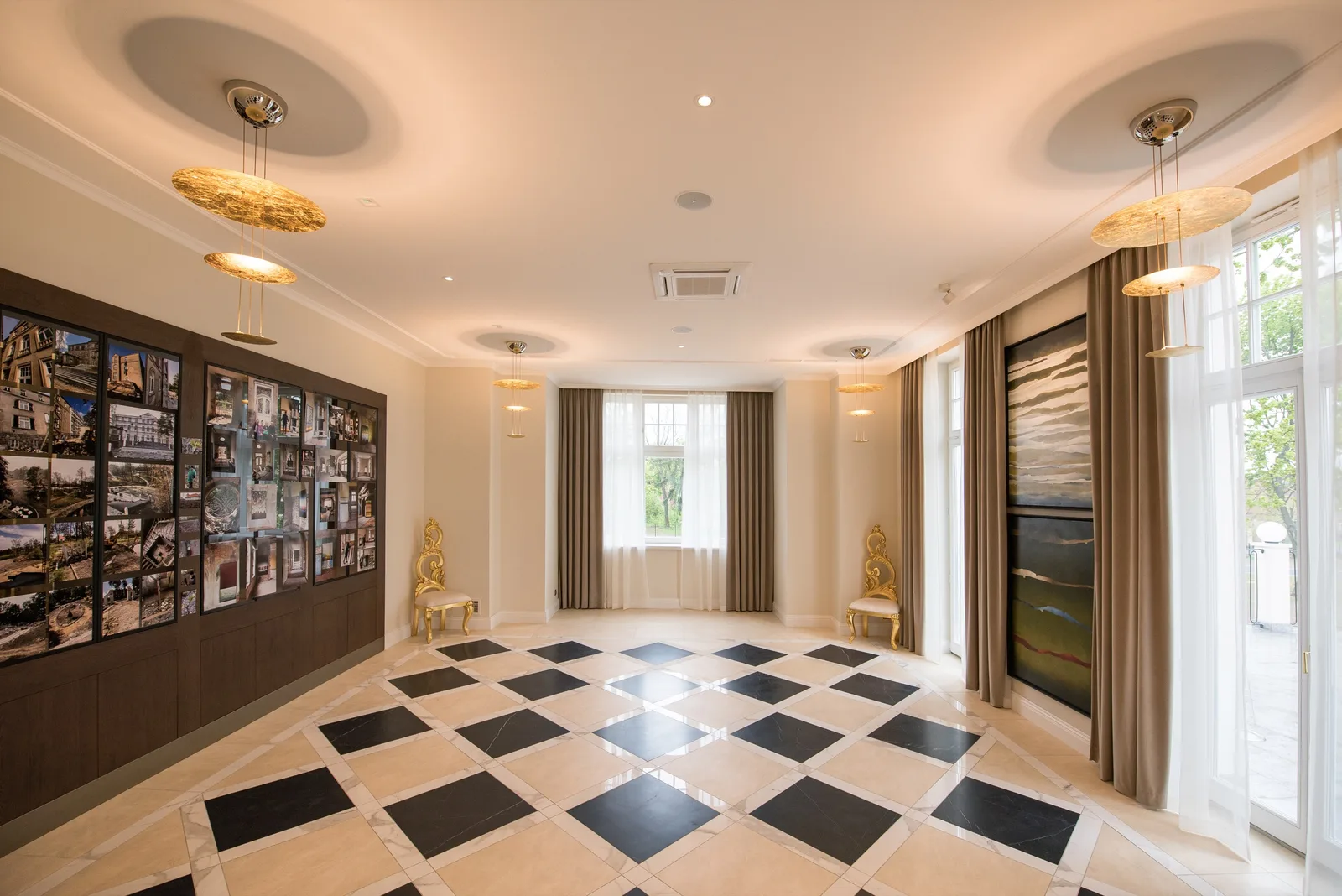 Event room with photo wall display, gold pendants, and diamond checkered floor pattern