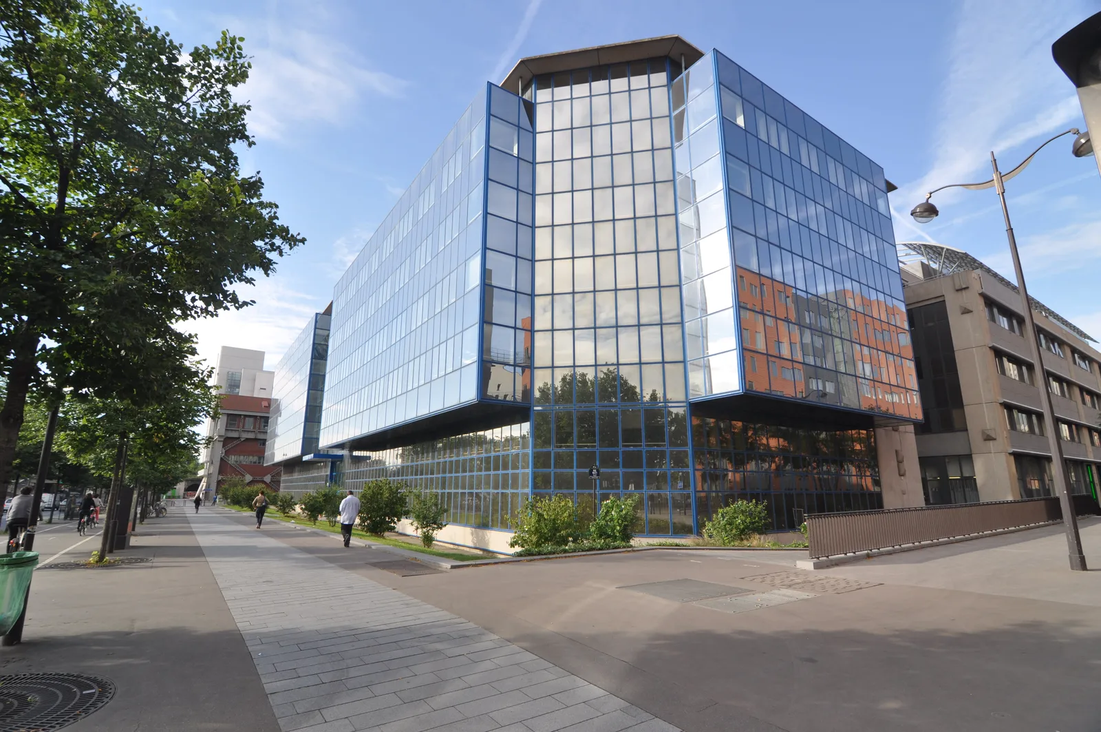 Before: exterior photograph of the Seinergy building showing glass and metal facade, multi-storey office tower in urban street context before renovation