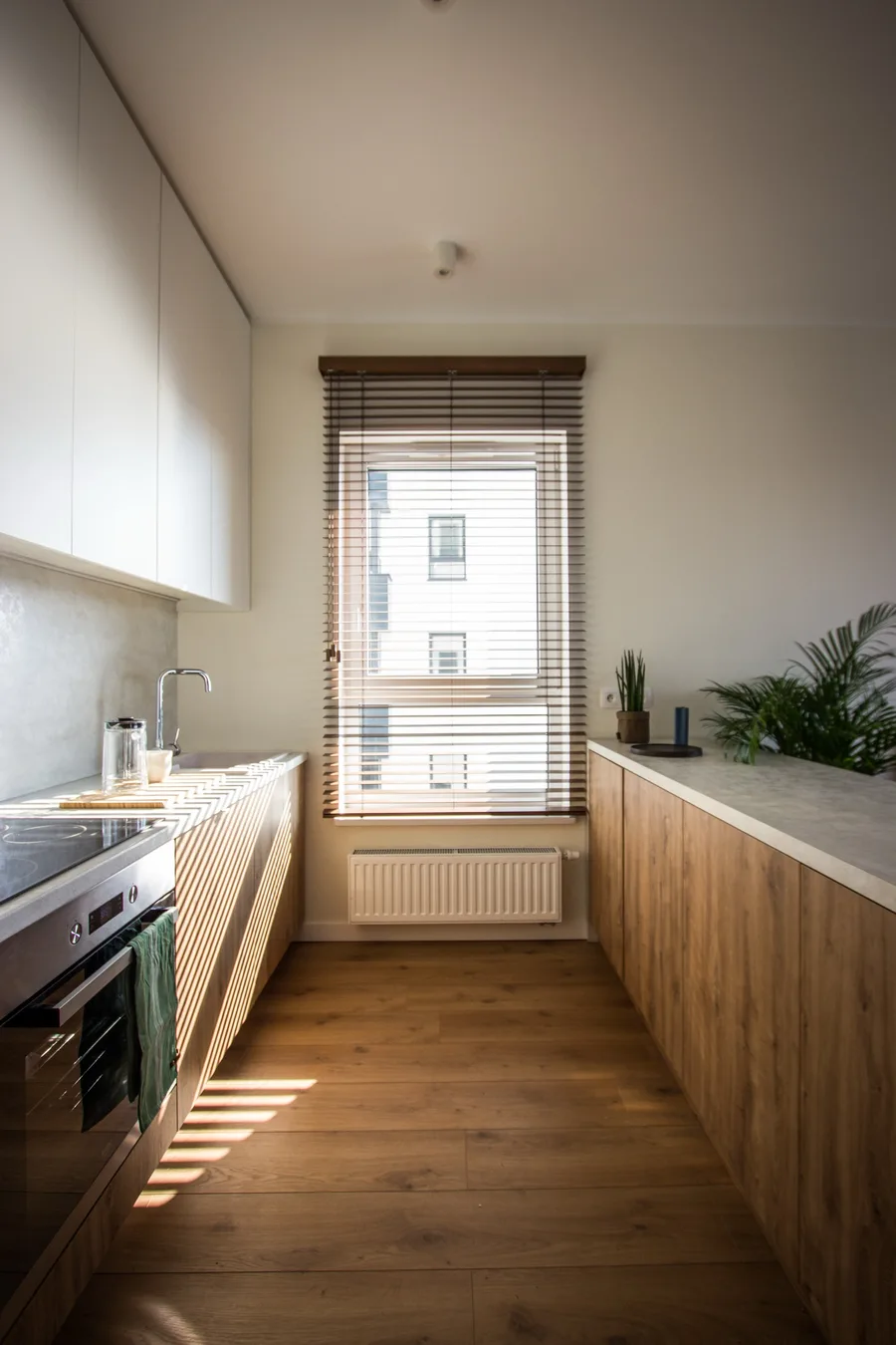 Bedroom wardrobe detail showing oak and black laminate doors reaching full ceiling height with chrome hanging rail visible