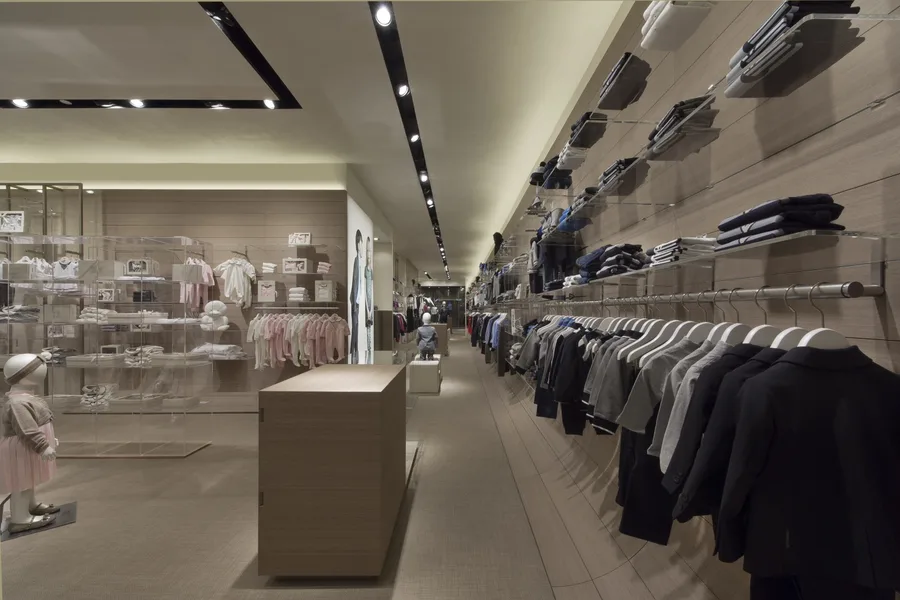 Interior: Doha store render with AJR design language showing warm cream palette, timber veneer walls, and signature recessed beam lighting in compact mall unit
