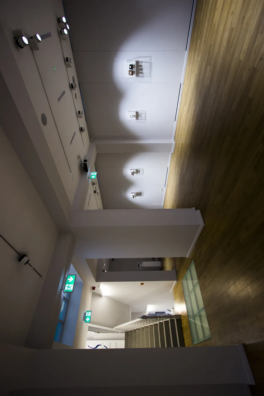 Interior: multi-level gallery corridor showing contemporary white drywall insertions contrasting with original exposed industrial structure, timber beams, and red brick walls