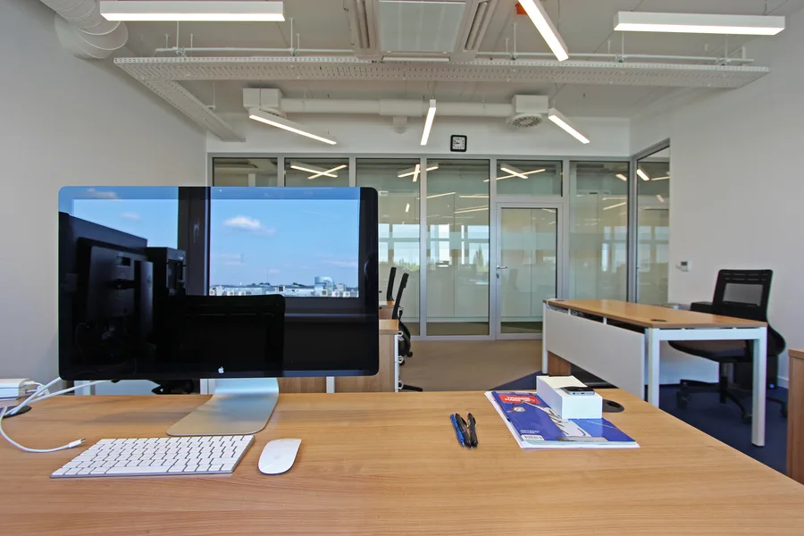 Open office with woven vinyl floor pattern extending through the workspace, demonstrating the continuous three-colour palette across the floor plate