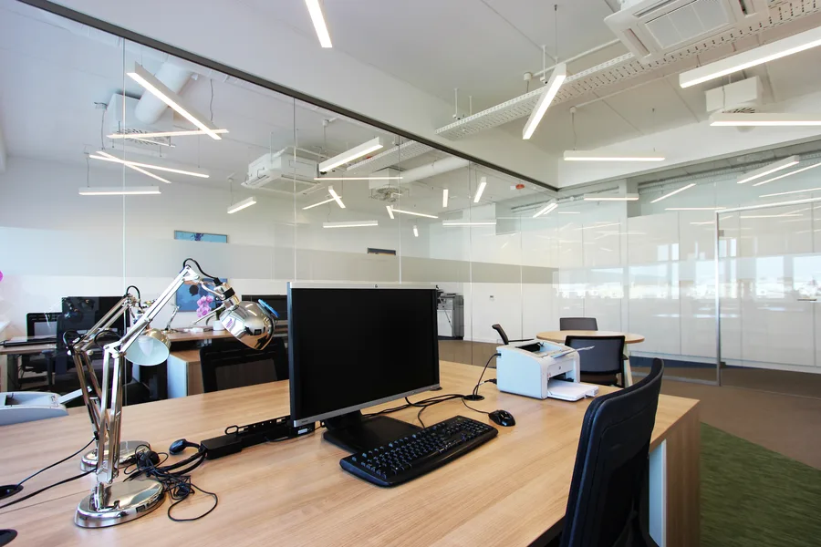 Office panoramic view across the open-plan workspace showing the full extent of the woven vinyl floor composition and natural light from perimeter windows