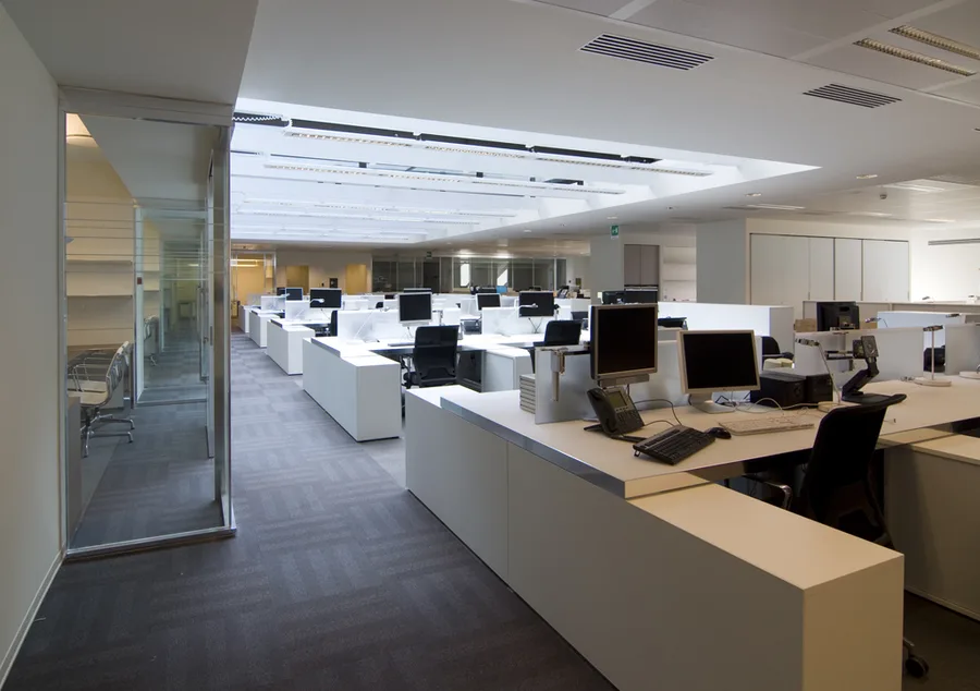Ground floor reception area with the Corian feature wall and bronze desk illuminated by ambient LED backlighting