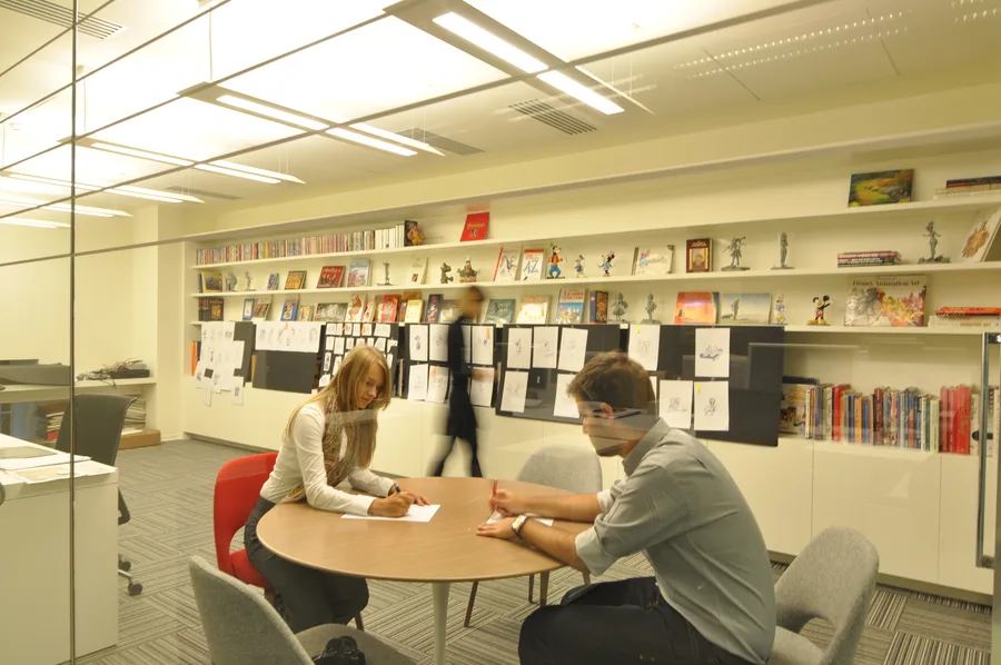 Creative studio interior showing the glass-walled workspace with character art and Disney merchandise collections
