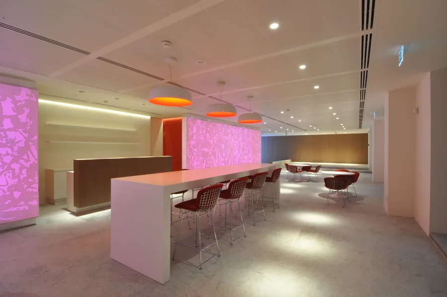Bar Corian panels in pink lighting mode, showing the LED colour-changing system that transforms the ground floor atmosphere