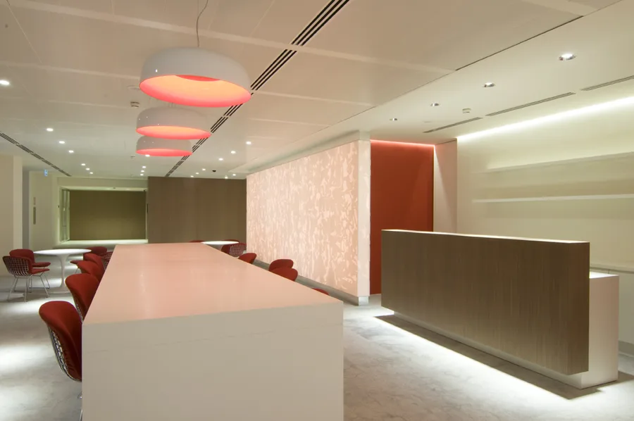 Professional photography of the bar zone showing Artemide Skydro pendants, Corian panel relief, and Bertoia Diamond chairs in evening light