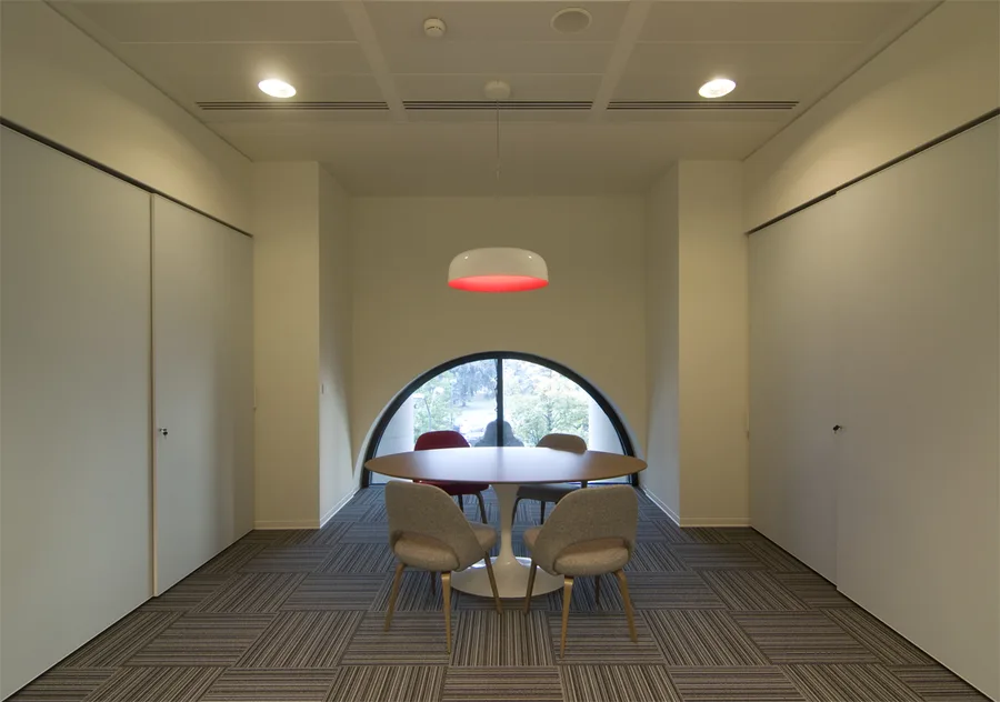 Level 2 meeting room within the Palazzo Aporti heritage arched structure, modern glass partitions inserted beneath 19th-century brick vaults