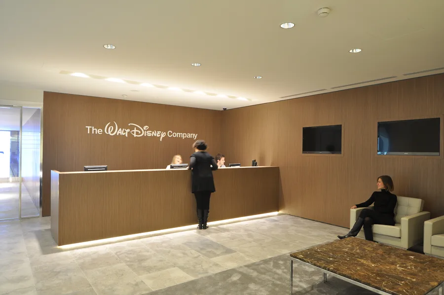 Wide-angle view of the Disney Italia reception and Corian feature wall with LED backlighting in ambient mode