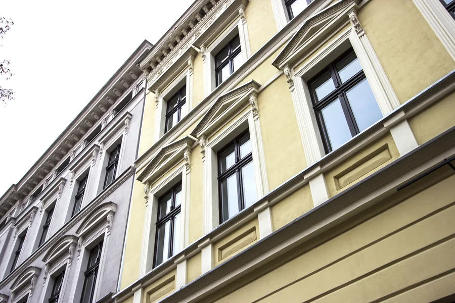 Yellow building upper floors similar angle, slightly tighter crop, window surrounds and facade ornament