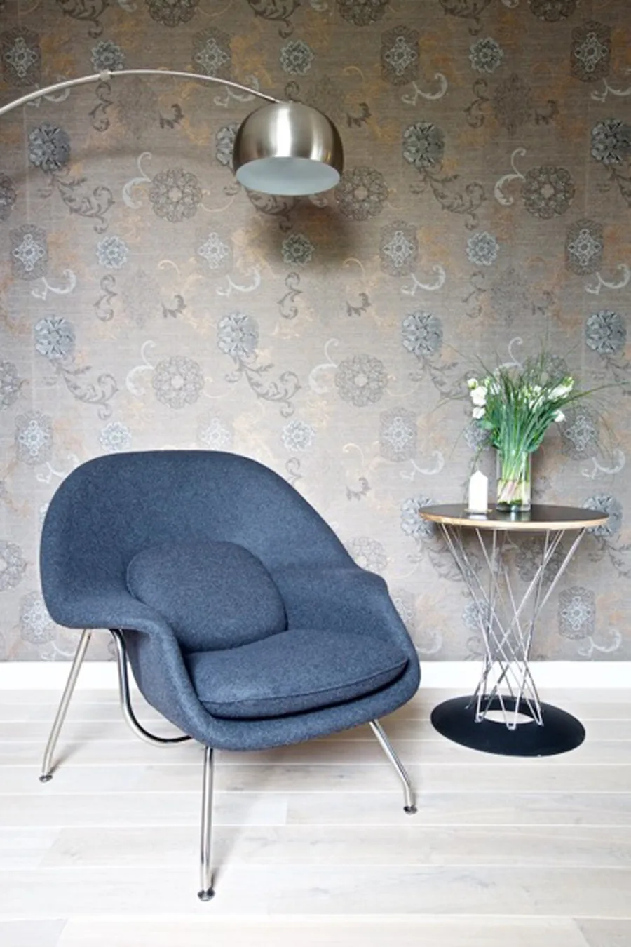 Furniture vignette with Eero Saarinen Womb chair, Achille Castiglioni Arco lamp, and Noguchi coffee table on herringbone oak floor