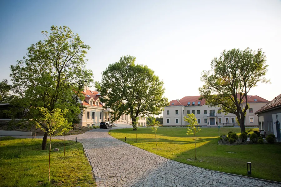 Summer golden-hour panorama of the Herbarium estate showing the full property scale within its lakeside parkland setting