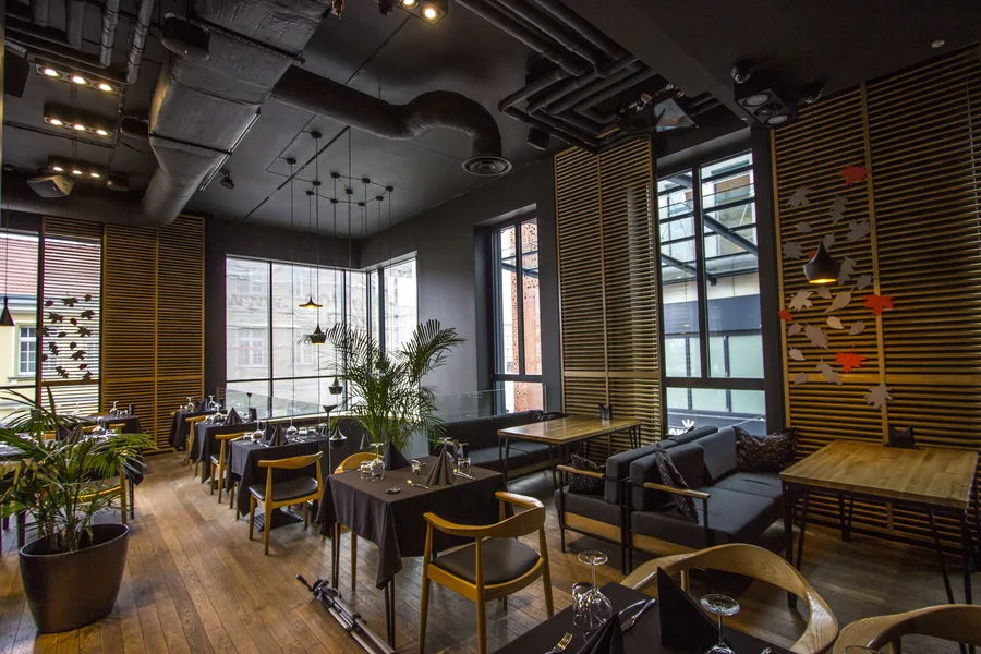Interior: upper floor dining and lounge with butterfly wall art, oak venetian blinds, grey sofas, palm plants, and koi-inspired paper stars