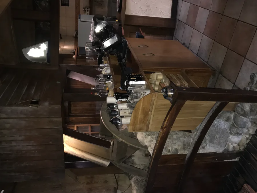Documentary: before-renovation photograph showing the old indoor stream feature running between dining tables with wooden bridge railings — the literal port theming replaced by the glass aquarium centrepiece