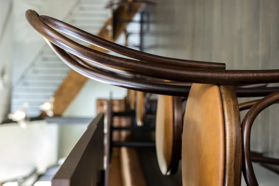 Fameg A-18 bentwood chair showing curved timber frame, woven cane seat, and dark walnut finish