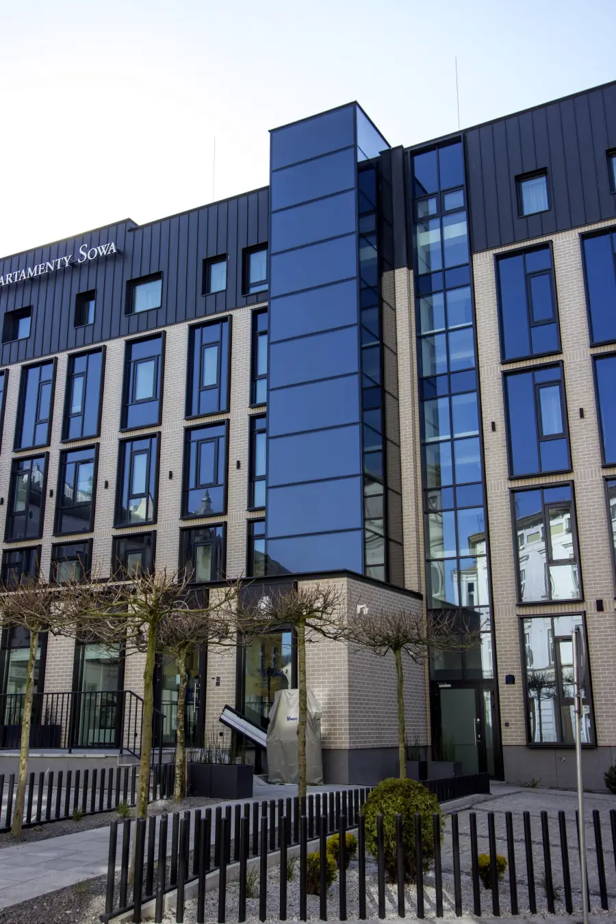 Full building facade with dark metal cladding