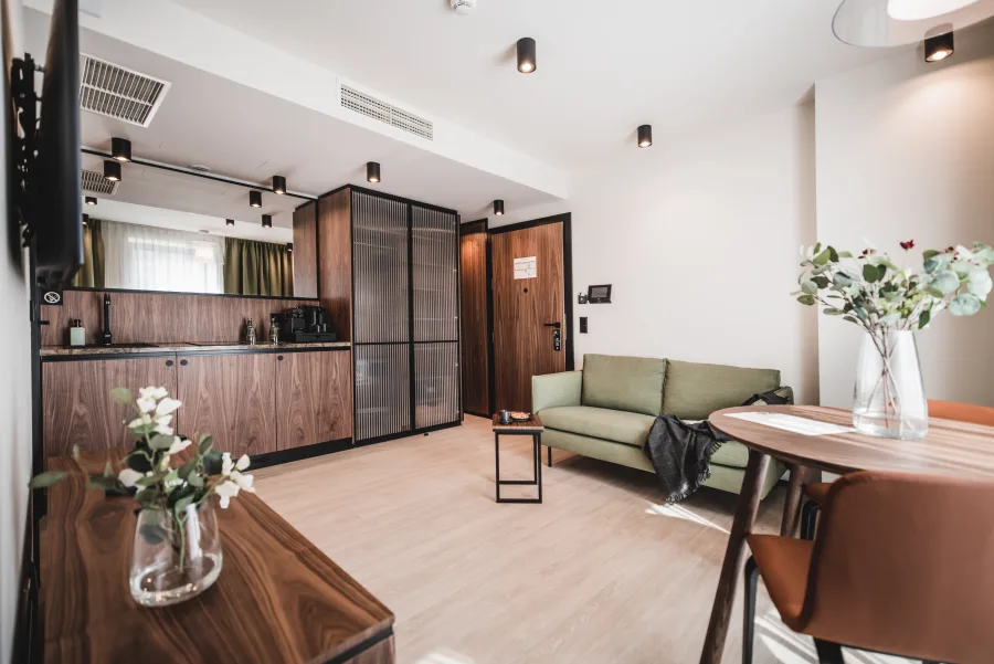 Room with kitchenette, walnut cabinet, flowers on table