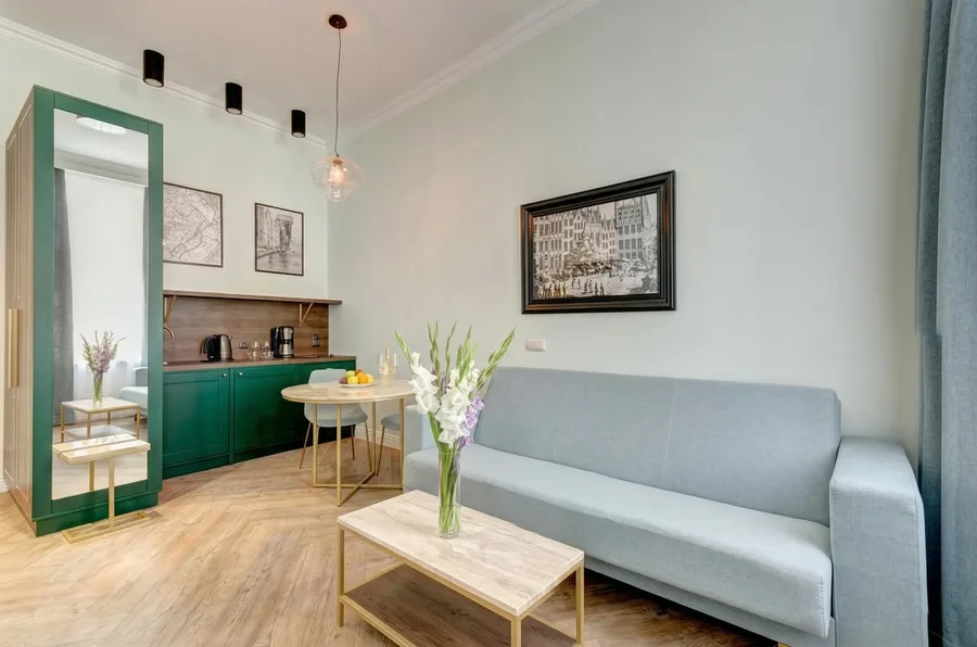 Wide panoramic view of the Sowa Gdansk interior with pendant lighting, green plants, and Art Deco brass accents
