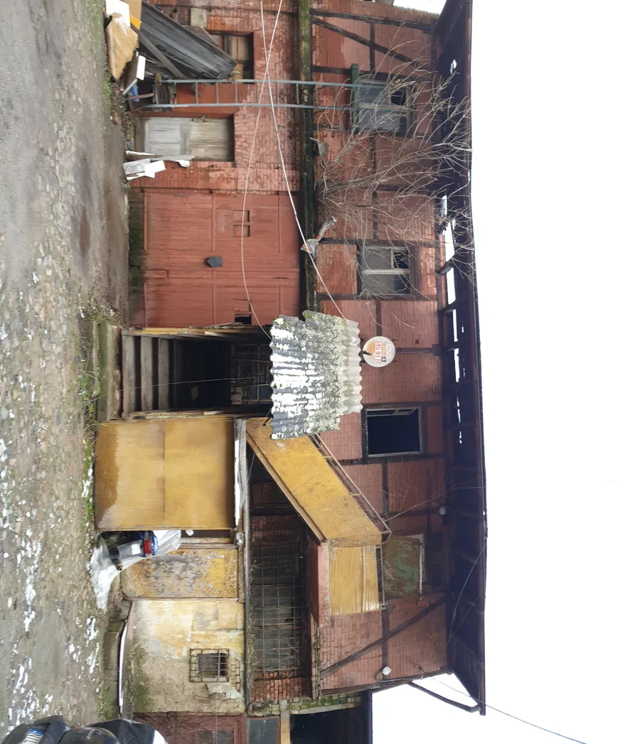 Before: detail of original heritage doorway with damaged timber frame, broken transom window, and exposed brickwork surrounding the opening