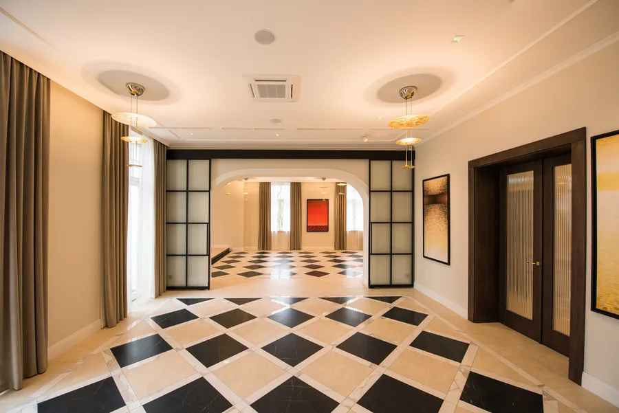 Glass partition steel-frame doors with reeded glass panels separating rooms with checkered floor
