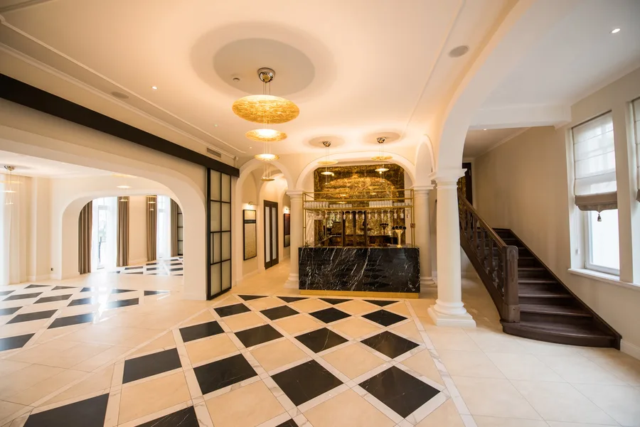 Lobby wide angle showing reception desk, staircase, and glass partition leading to corridor