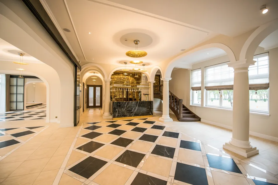 Lobby panorama with columns, arches, reception desk, and ornamental staircase beyond