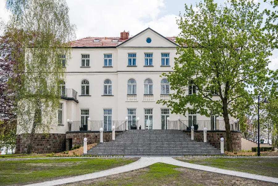 Palace front facade with grand stone staircase, symmetrical composition showing the full 1906 heritage building