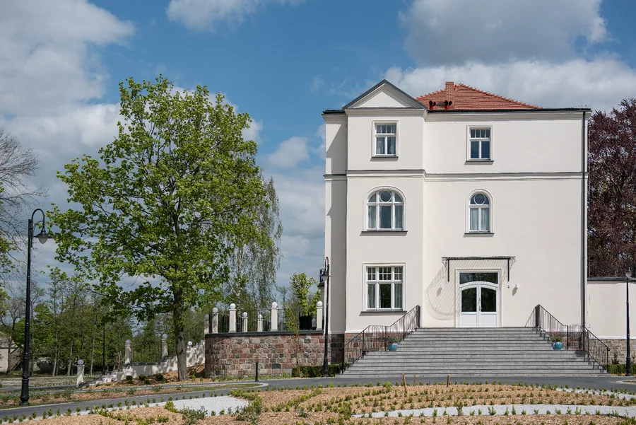 Side wing view with gardens, ornamental plantings, and corner tower of the palace