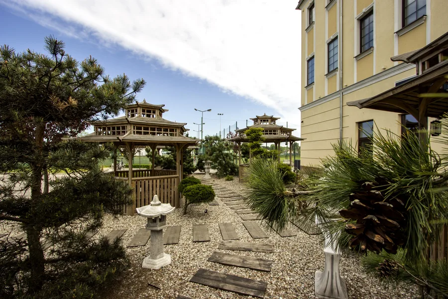 Exterior: side view of Japanese garden with pagodas, stone lanterns, stepping stone path, sepia and warm tone